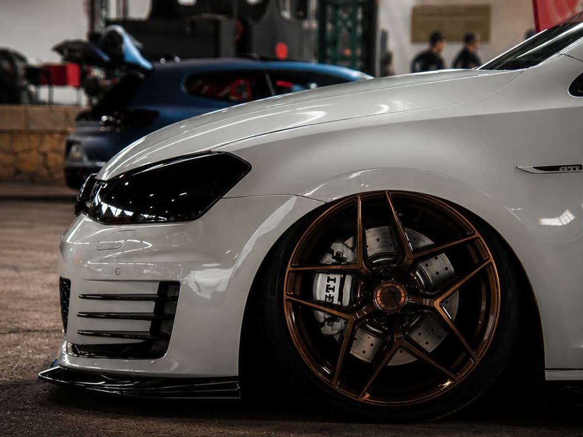 Detalle de la llanta de un Golf GTI blanco preparado durante una colaboración