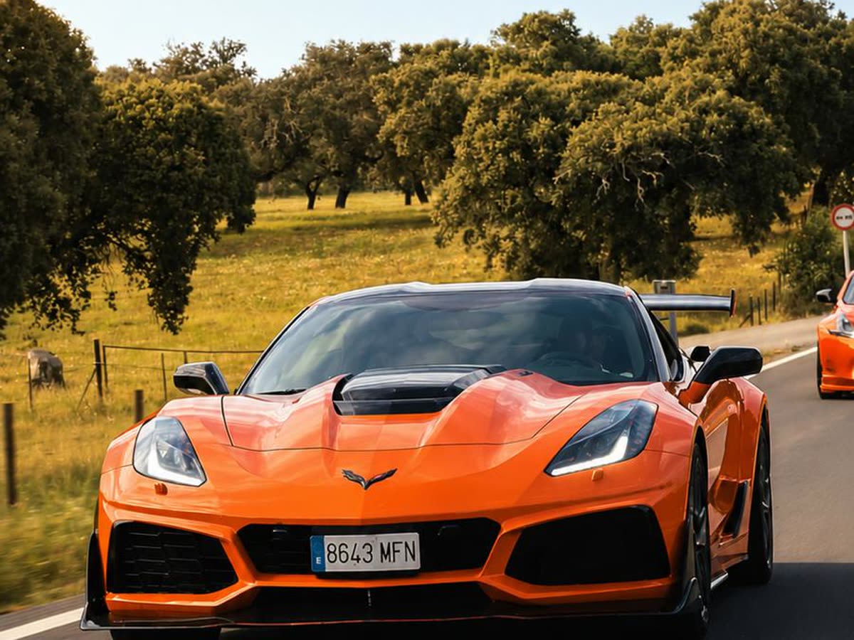Corvettes naranjas rodando juntos en una ruta del club